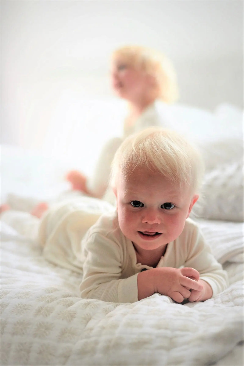 Flower Child Cotton Muslin Newcastle Blanket with baby resting.