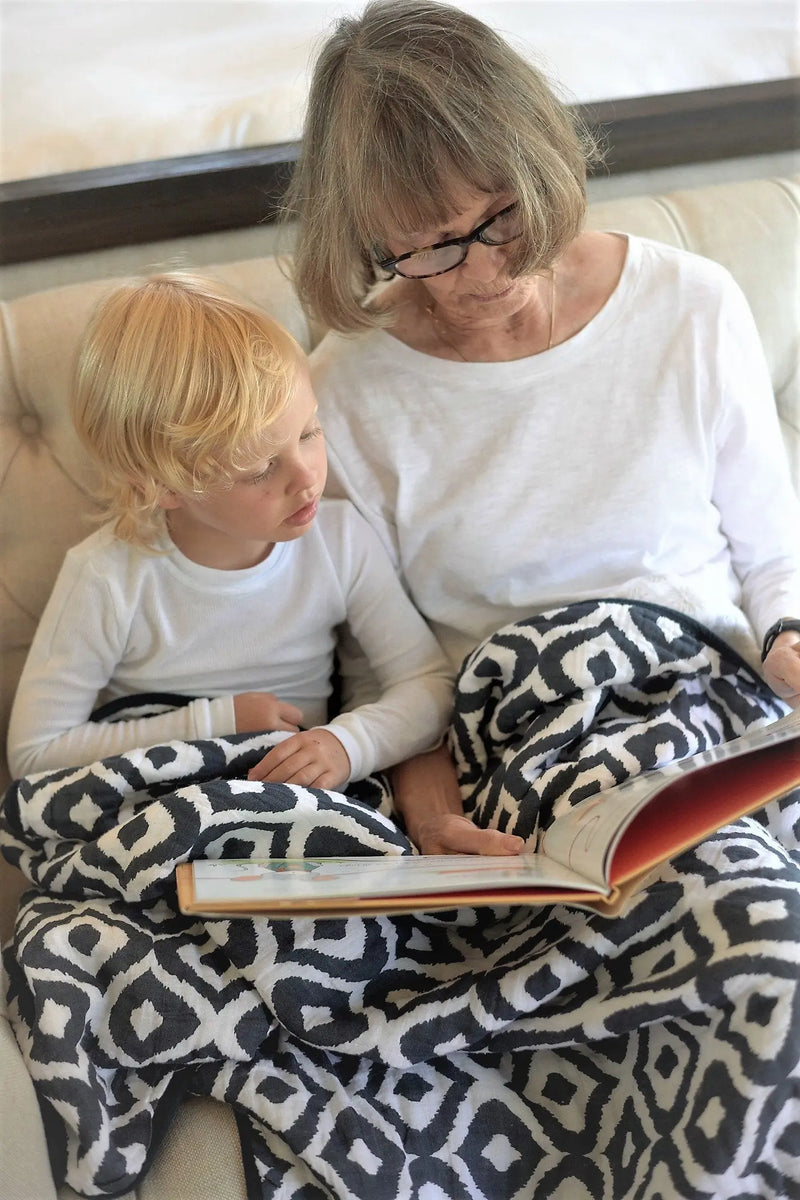 Morrocan Blue And Flower Child cotton muslin blanket with a geometric pattern, perfect for snuggling.