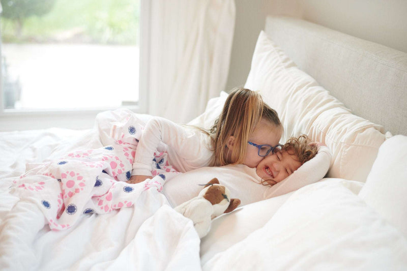 Children on bed with Primrose Indigo Cotton Muslin Swaddle.