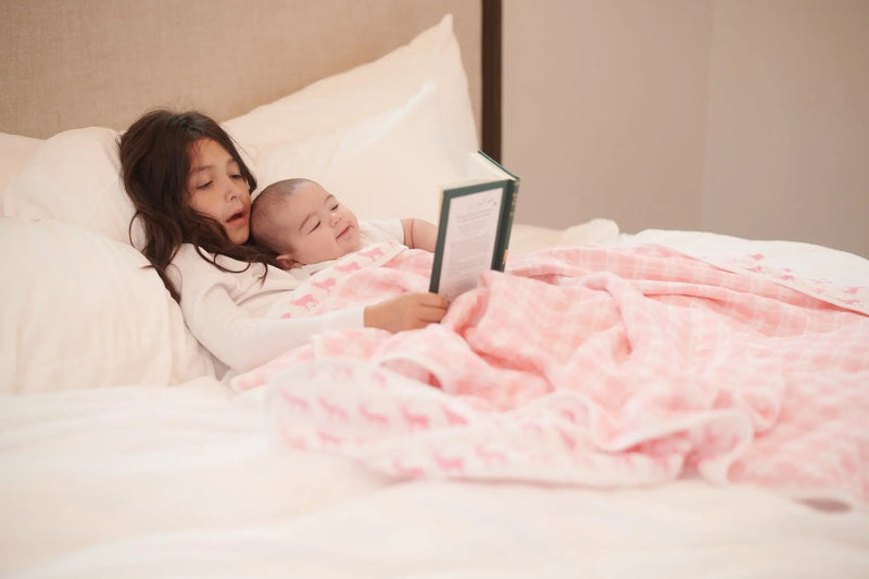 Pink Deer and Primrose Pink Plaid Cotton Muslin Blanket on bed with children.