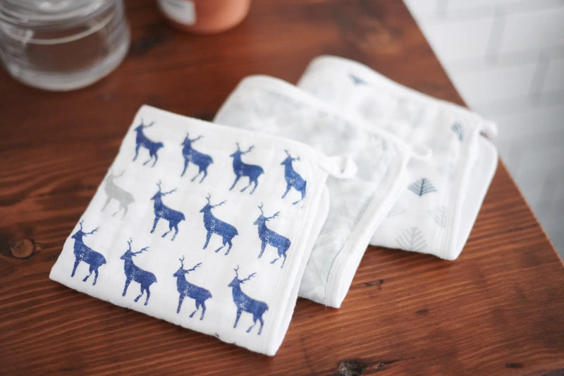 Blue Deer Cotton Washcloth Set 3PK with plush cotton and colorful prints on a wooden surface.