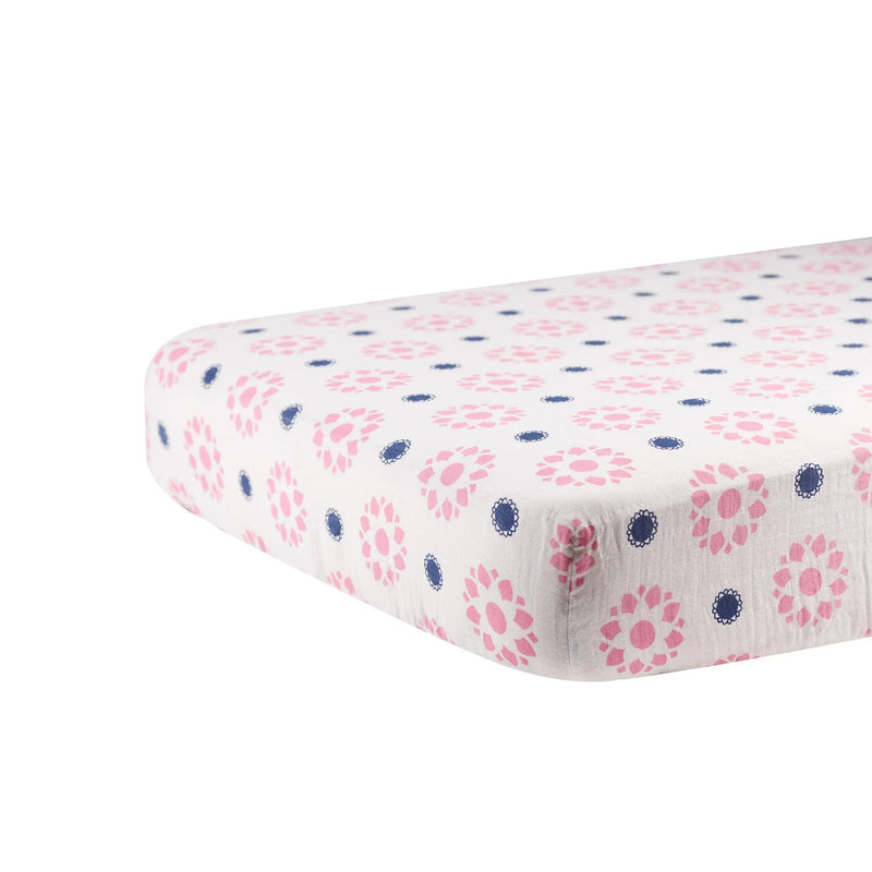 Primrose Indigo Cotton Muslin Crib Sheet with floral pattern on a mattress.