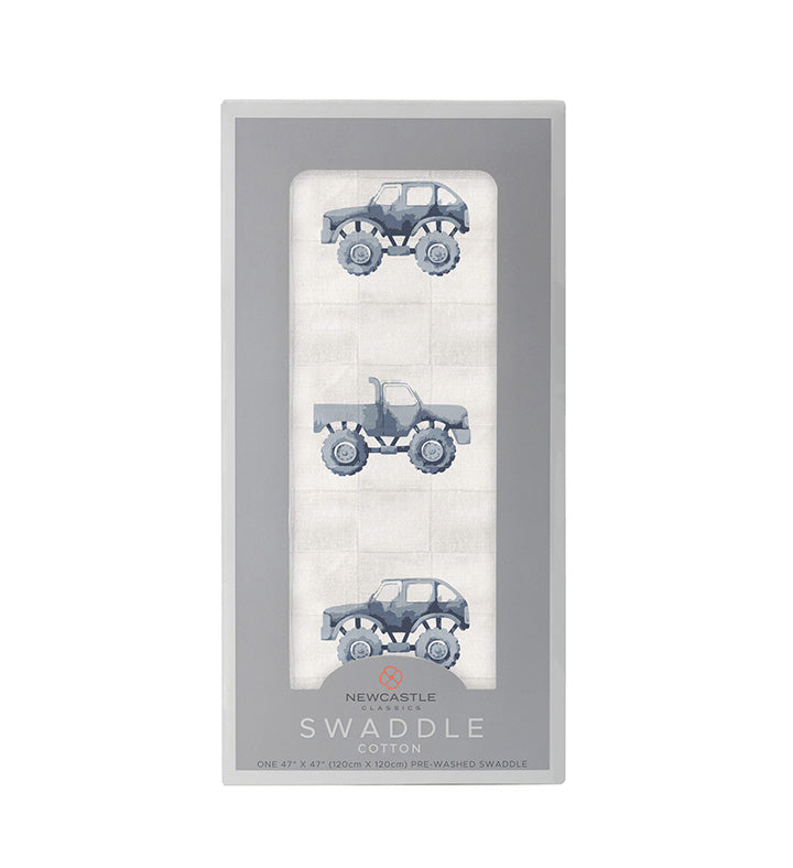 Cotton muslin swaddle blanket in indigo with a monster truck pattern spread flat