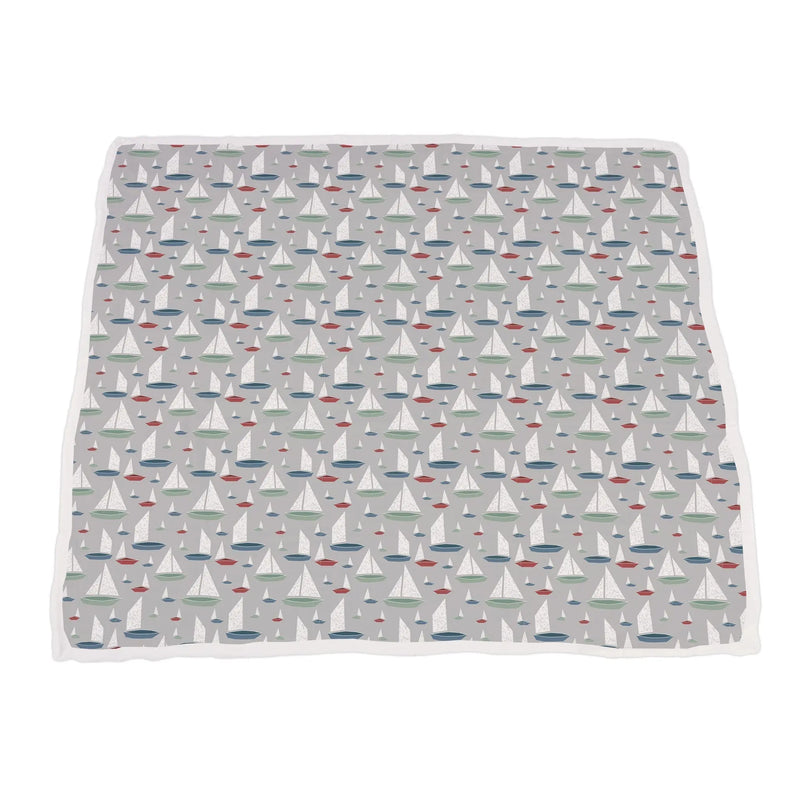 Bamboo muslin blanket with ocean palm tree and sailboat pattern.
