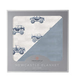 Muslin baby blanket with indigo monster truck print on a blue fog background