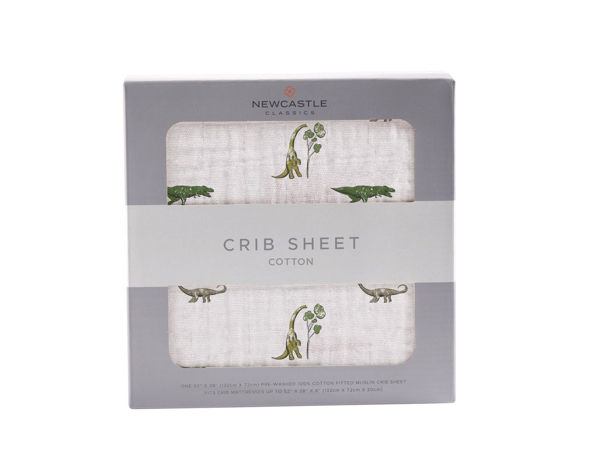 Cotton muslin crib sheet with a Dino Days dinosaur print fitted on a crib mattress
