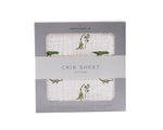 Cotton muslin crib sheet with a Dino Days dinosaur print fitted on a crib mattress