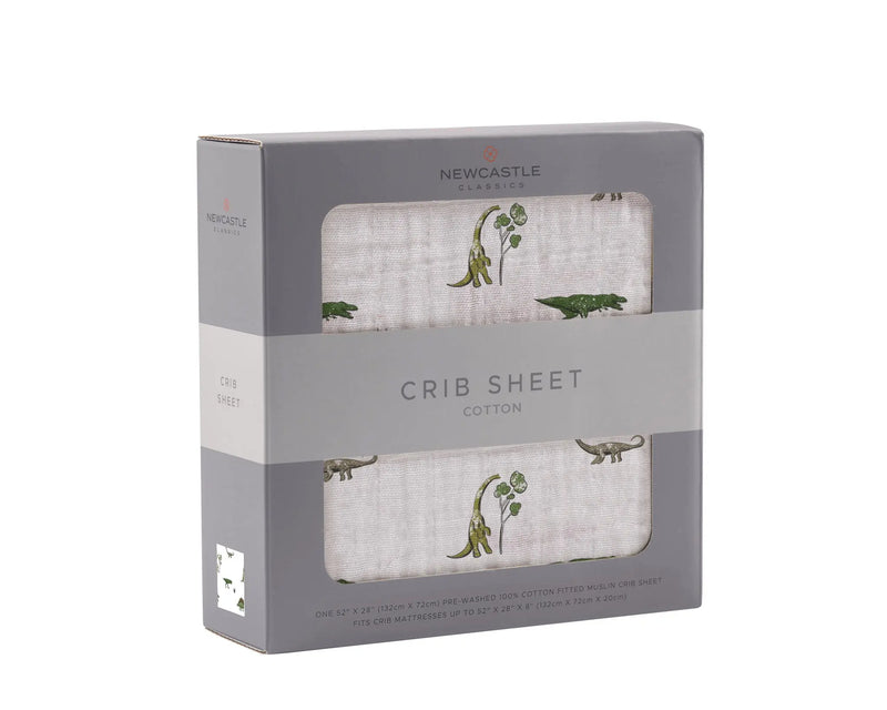 Dino Days Cotton Muslin Crib Sheet in packaging with dinosaur print, 100% natural cotton.