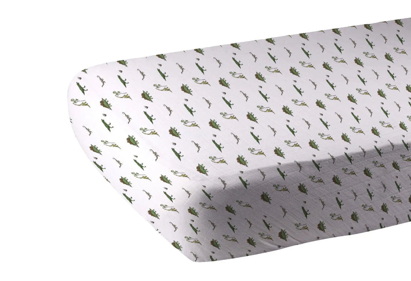 Dino Days Cotton Muslin Crib Sheet with dinosaur print on a crib mattress.