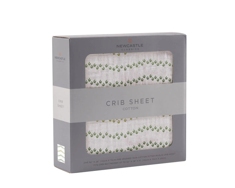 Dino Feet Cotton Muslin crib sheet in packaging, natural and breathable.