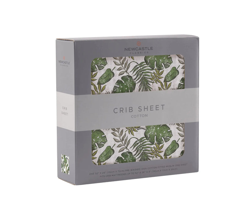 Natural cotton muslin crib sheet with tropical forest design in packaging.