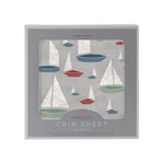 Bamboo muslin crib sheet with a marina sailboats print in blue and white on a fitted crib mattress
