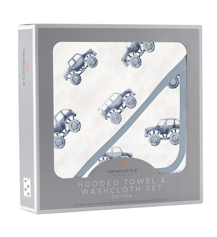 Soft indigo cotton hooded towel featuring monster trucks, with a matching washcloth folded beside it.