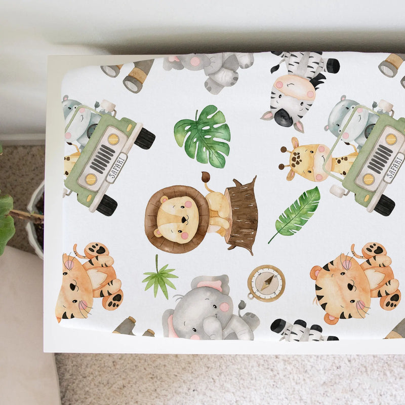 Safari-themed changing pad cover with animal designs, soft and stretchy fabric.