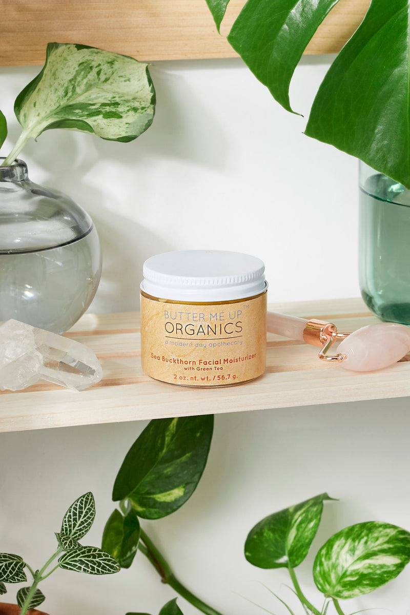 Sea Buckthorn Facial Moisturizer in glass jar on a shelf with plants.