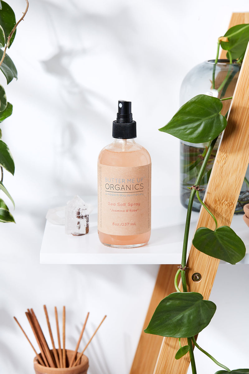 Pink Himalayan Sea Salt spray in 8oz glass bottle on shelf with plants.
