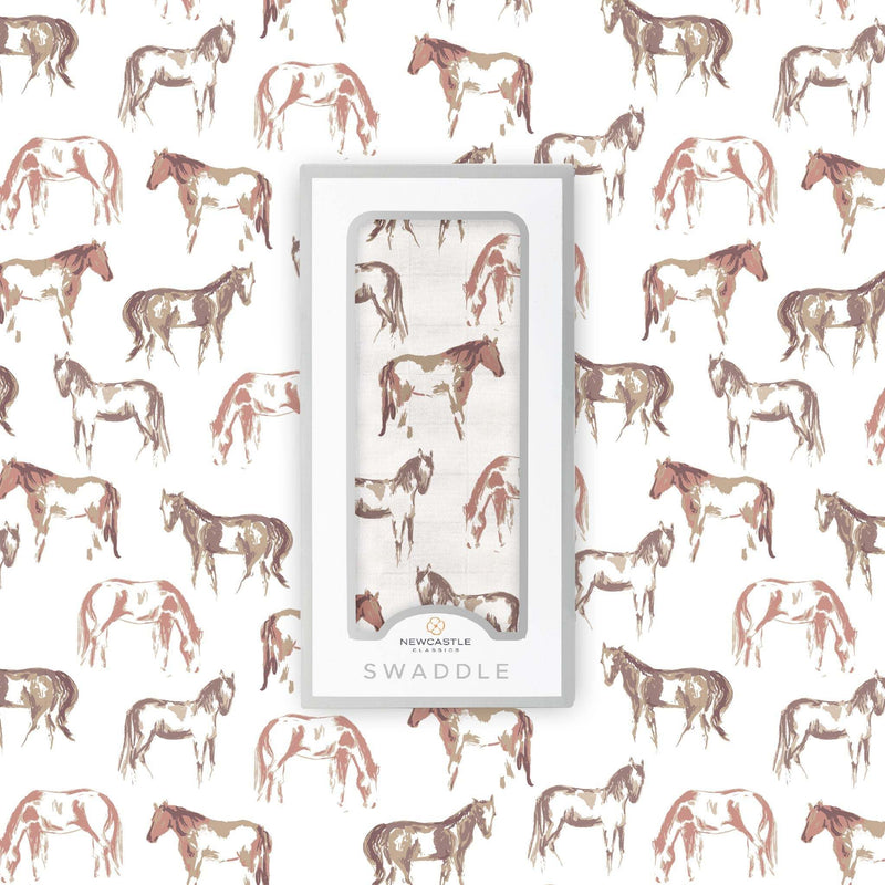 Wild Horses Bamboo Swaddle in packaging with horse pattern background.