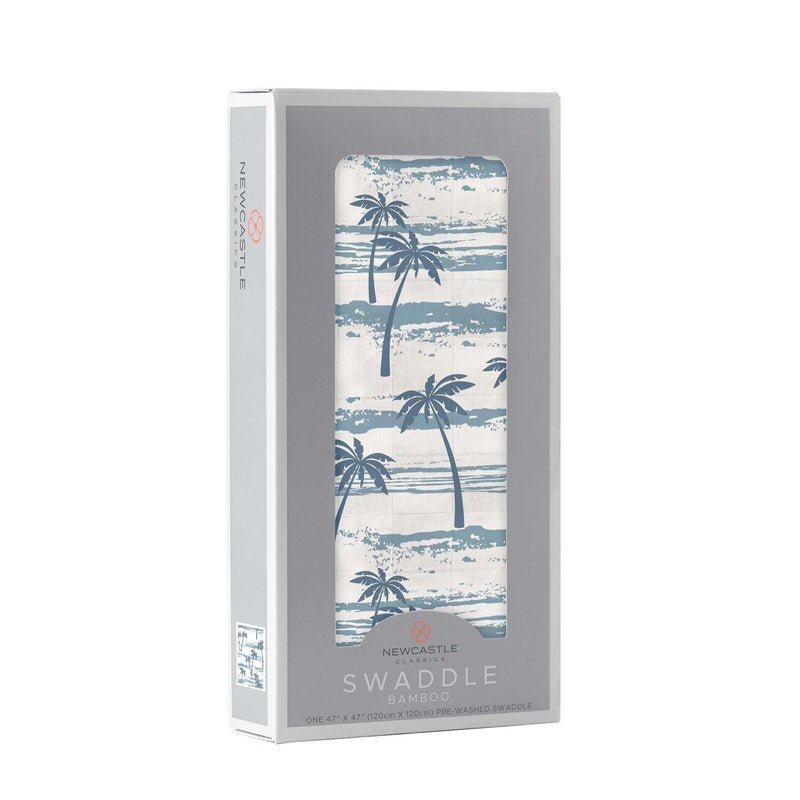 Ocean Palm Trees Bamboo Swaddle in packaging, featuring blue palm tree design on soft muslin fabric.