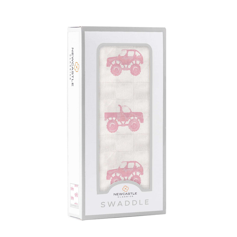 Pink monster trucks bamboo muslin swaddle in packaging.