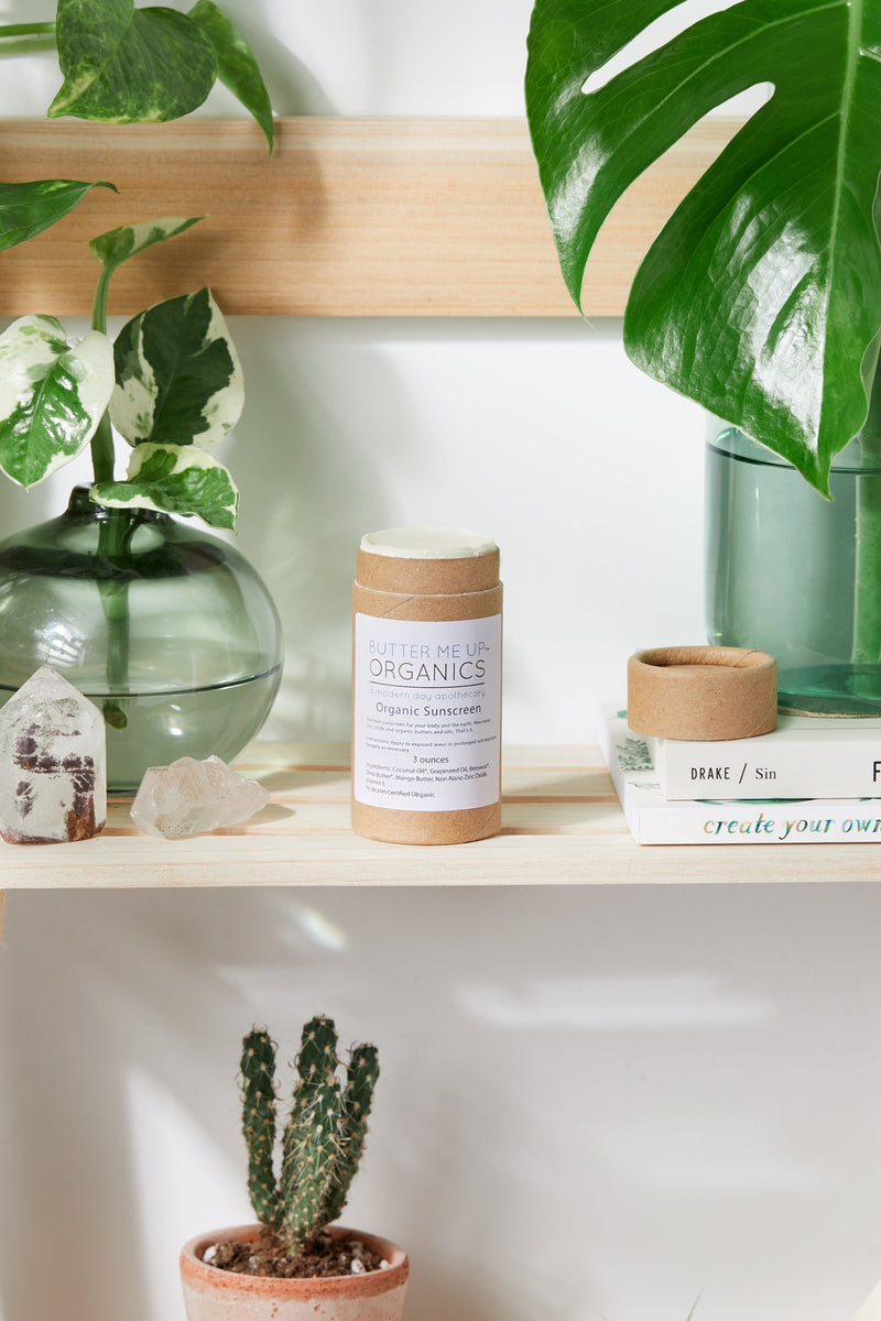 Natural organic sunscreen with non-nano zinc oxide by Butter Me Up Organics on shelf with plants.