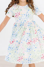 Short sleeve twirl pocket dress for children with a full skirt, scoop back and ballet neckline