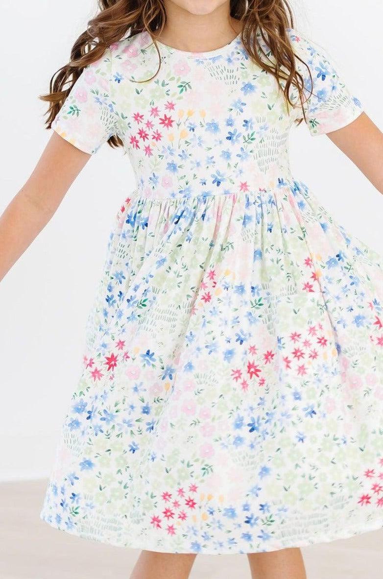 Short sleeve twirl pocket dress for children with a full skirt, scoop back and ballet neckline