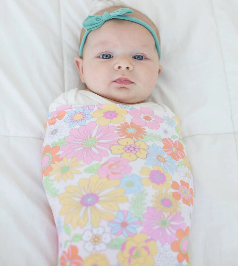 Buttery soft and stretchy retro floral swaddle blanket wrapping baby, providing comfort and style.
