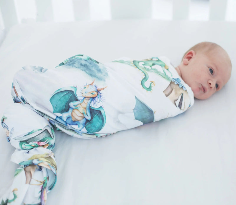 buttery soft and stretchy swaddle blanket with dragons and knights pattern wrapping a baby