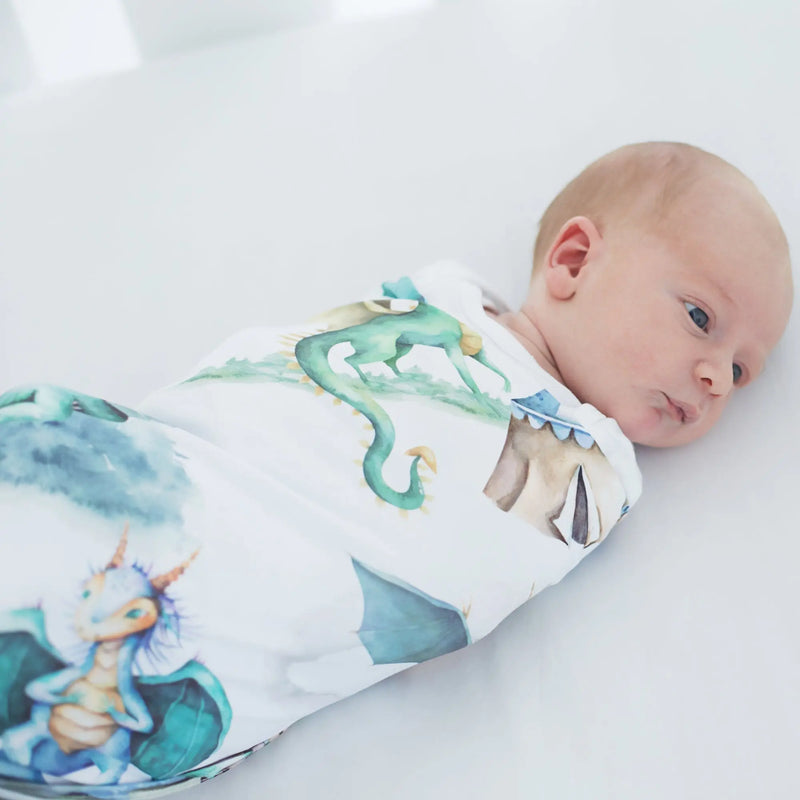 Baby wrapped in buttery soft and stretchy swaddle blanket with dragons and knights design.