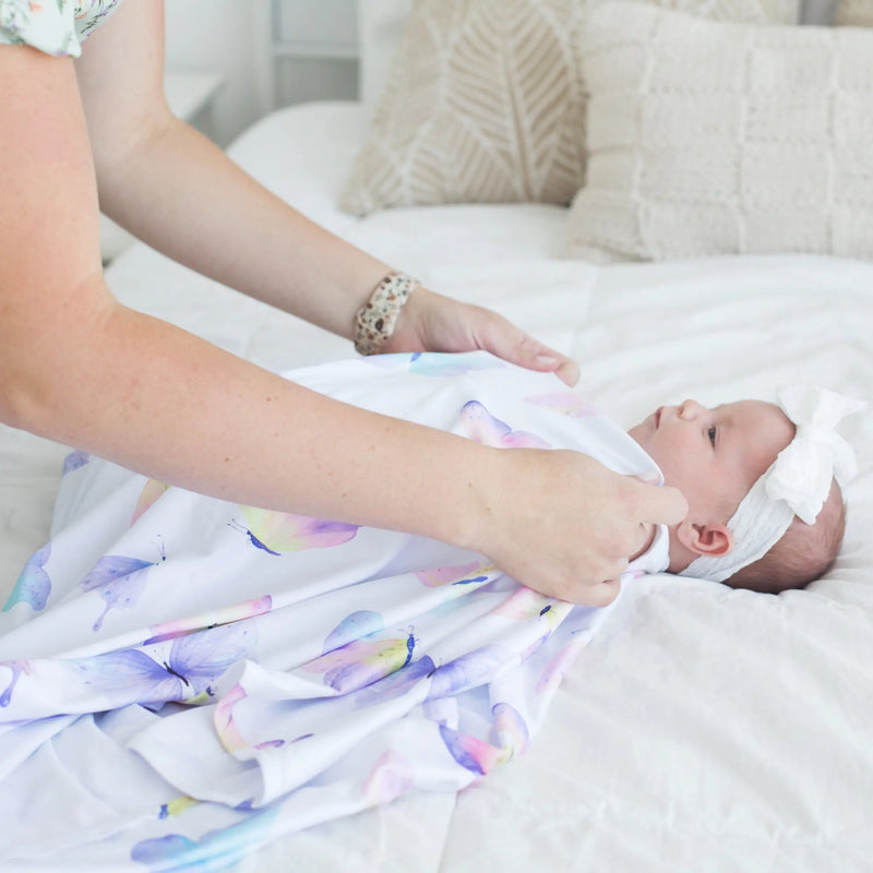 Buttery soft and stretchy swaddle blanket with butterfly pattern for baby comfort.