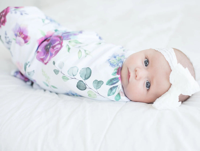 buttery soft and stretchy blue floral swaddle blanket wrapped around baby