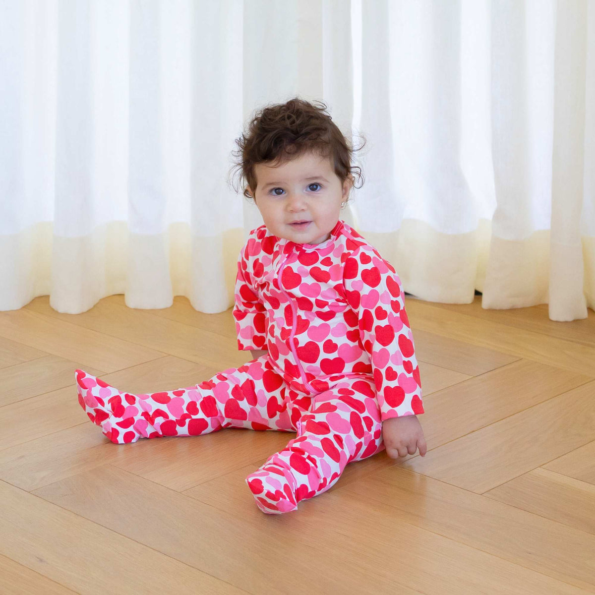 Norani Baby organic footie pajamas with red and pink hearts.