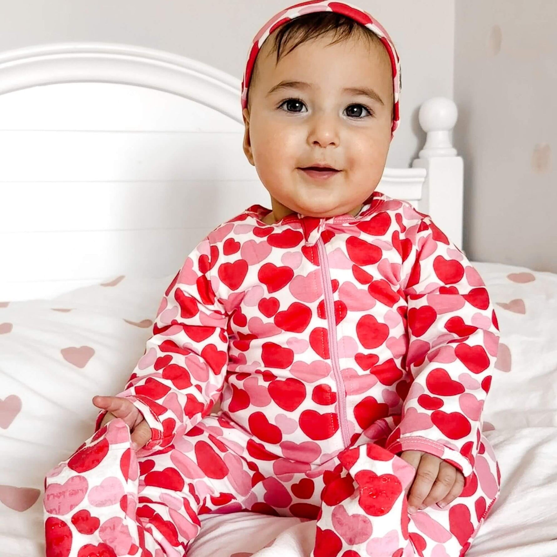 Norani Baby organic cotton footie pajamas with red and pink hearts.