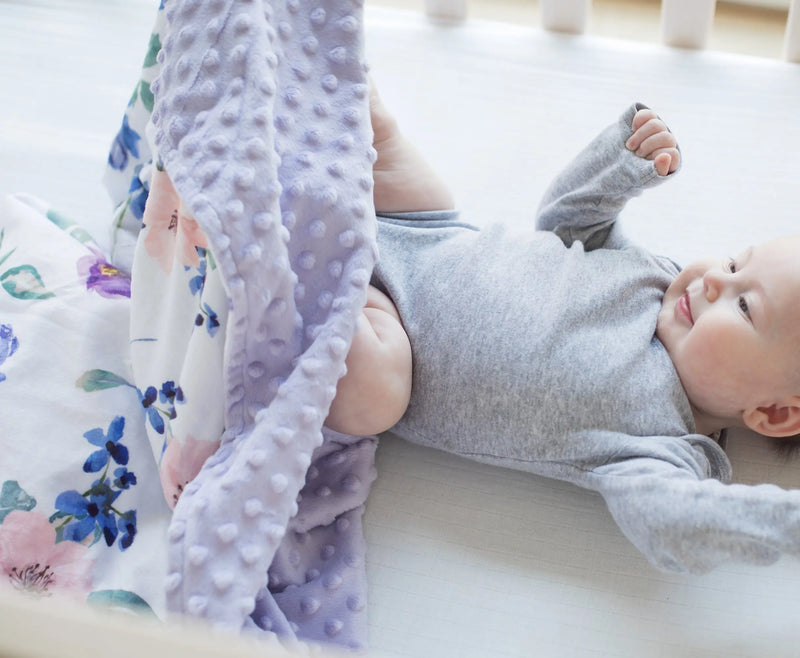 Premium baby and toddler blanket in purple and blush floral pattern with minky dot texture, ideal for delicate skin and sensory stimulation.
