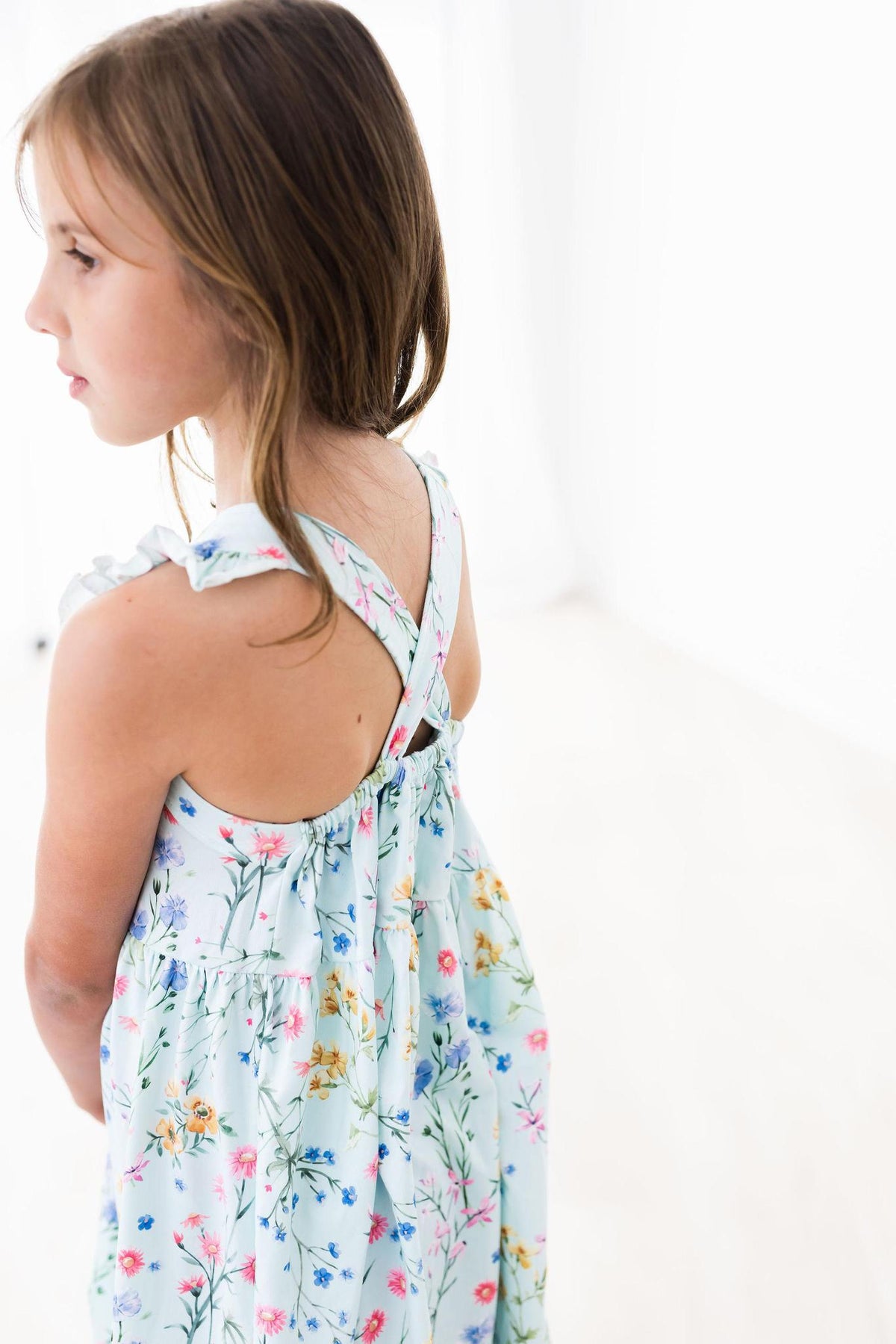 Ruffle cross back dress with criss-cross back straps and a shoulder ruffle in a wild woods print