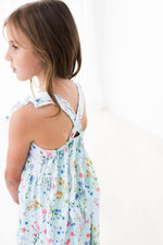 Ruffle cross back dress with criss-cross back straps and a shoulder ruffle in a wild woods print