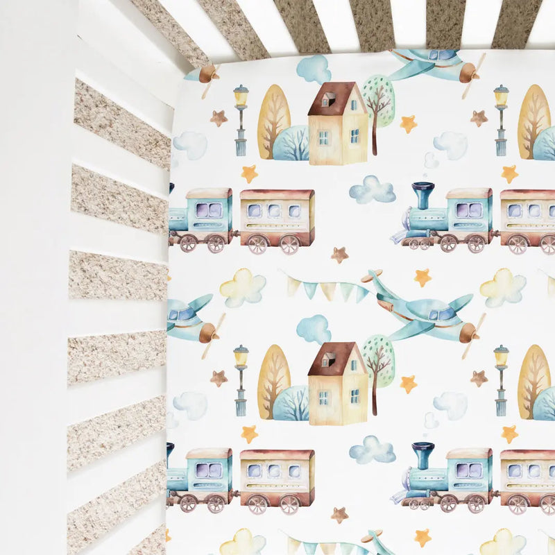 Fitted crib sheet with airplane and train pattern, standard size, soft rayon and spandex fabric.