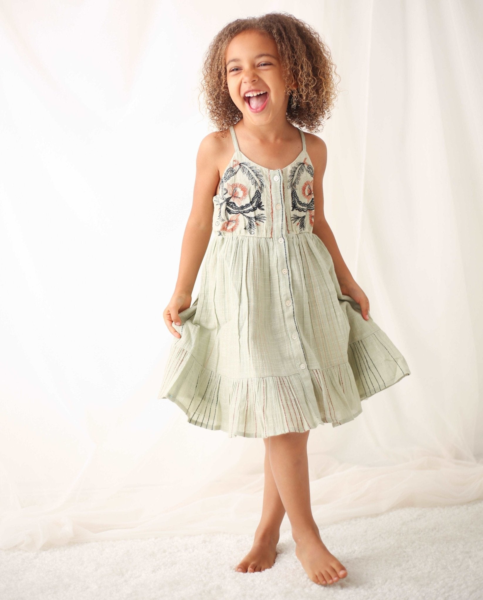 Girls' sage mini dress with red, black and metallic stripes, embroidered bodice, adjustable straps and front buttons