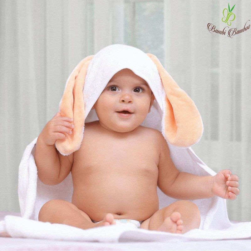 Baby wrapped in Amber Bunny Hooded Towel with washcloths, featuring cute bunny ears; made from 100% organic bamboo for softness and durability.