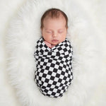 Charcoal and gray checked swaddle blanket laid flat with a gingham-style pattern
