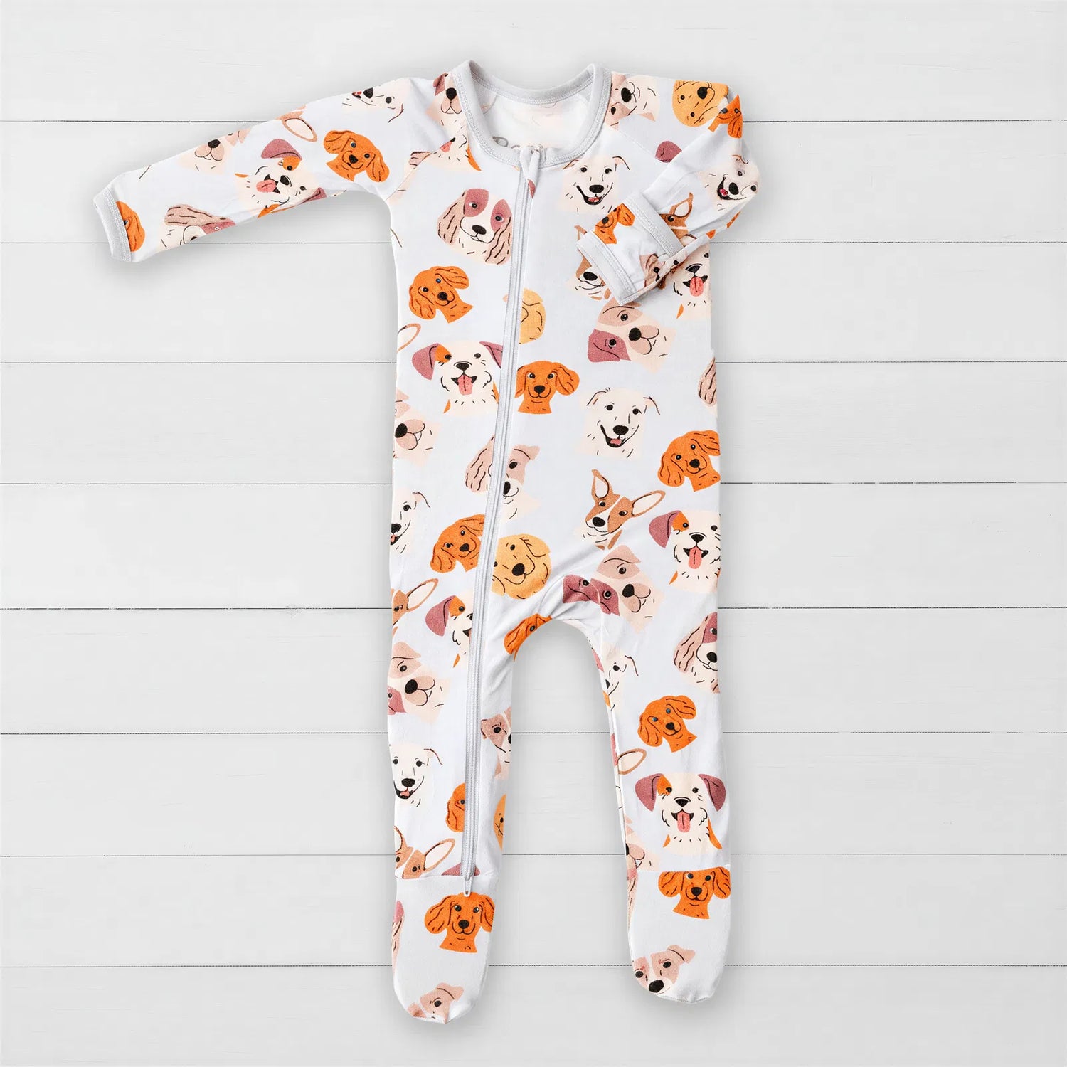 Baby footie pajamas with an all-over dog print and a two-way front zipper.