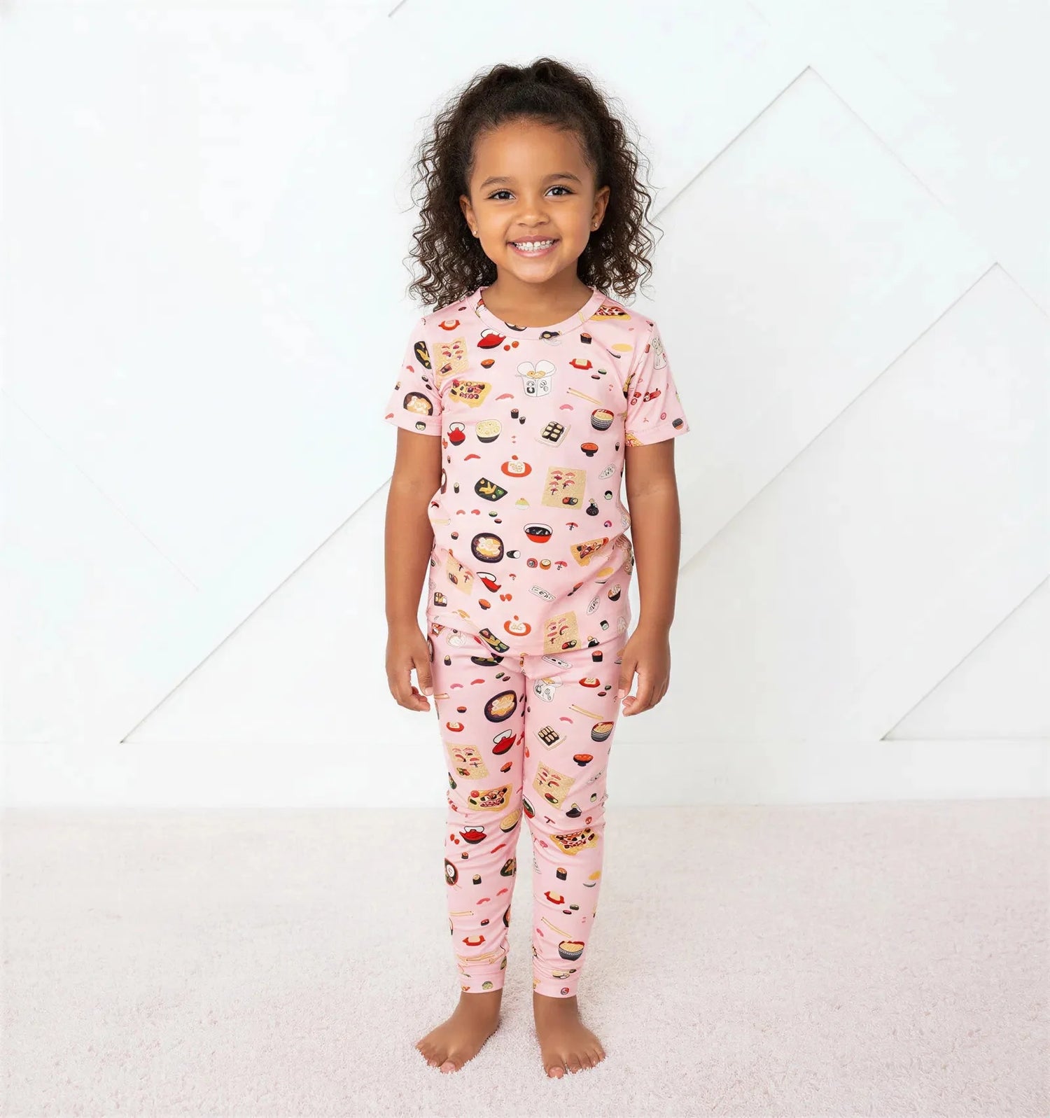 Pink short sleeve bamboo pajama set with sushi and ramen prints, matching top and pants.