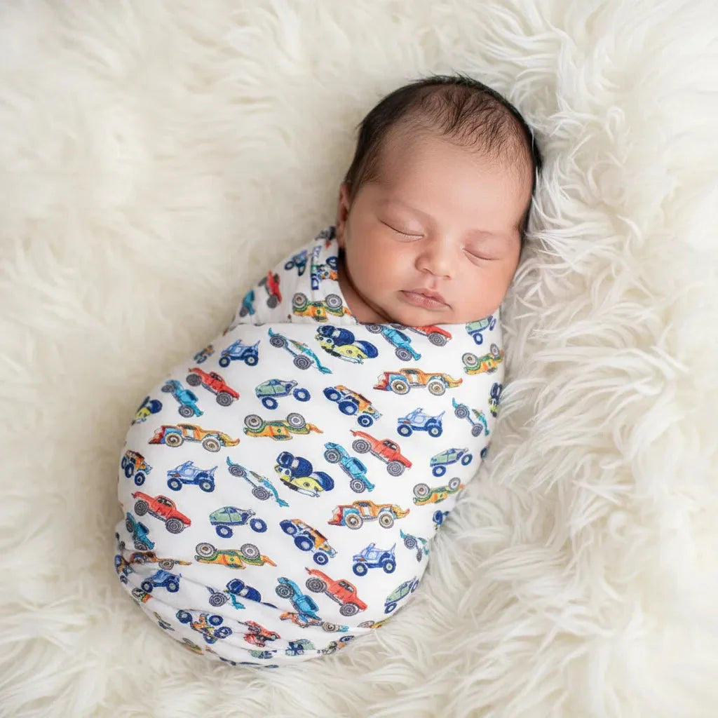 Oversized baby swaddle blanket with a wild wheels car and truck print