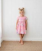 Twinkle Ties dress in pink with tie details and short sleeves, worn by a toddler.