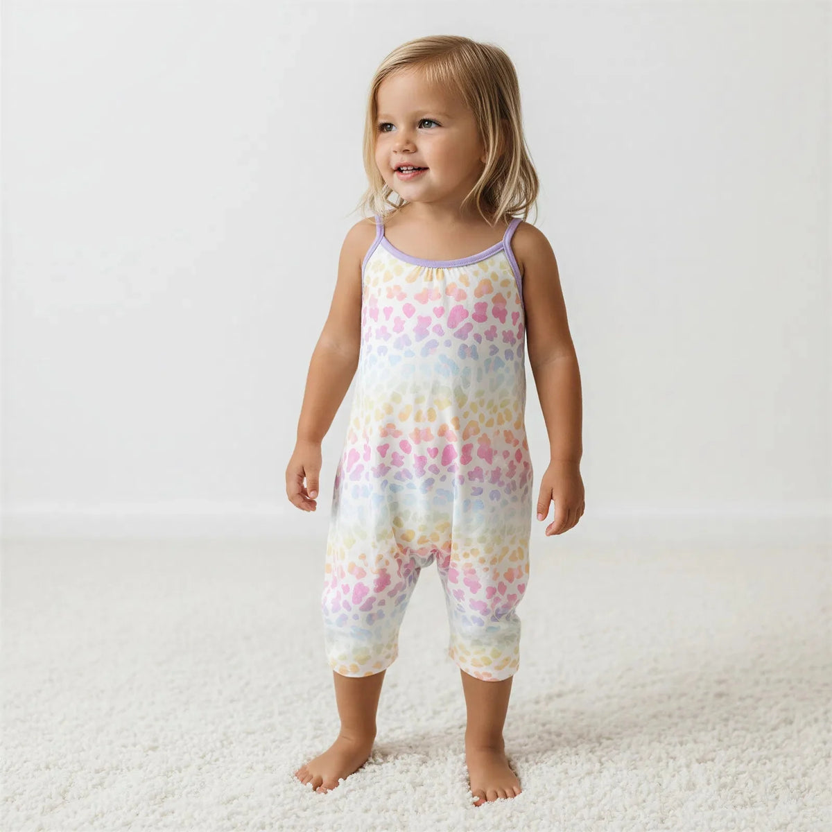 Toddler wearing a one-piece jumpsuit with pockets, standing outdoors