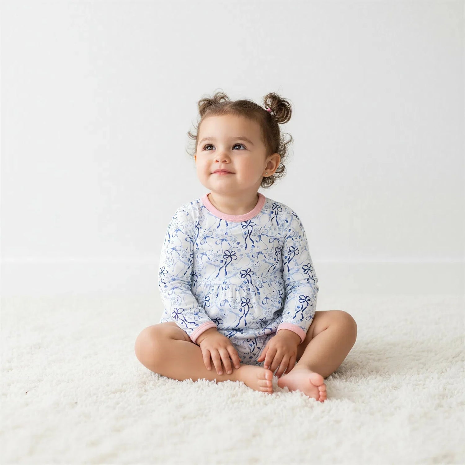 Long-sleeve bodysuit dress with blue bows, menorahs, Star of David and dreidel print on a light background