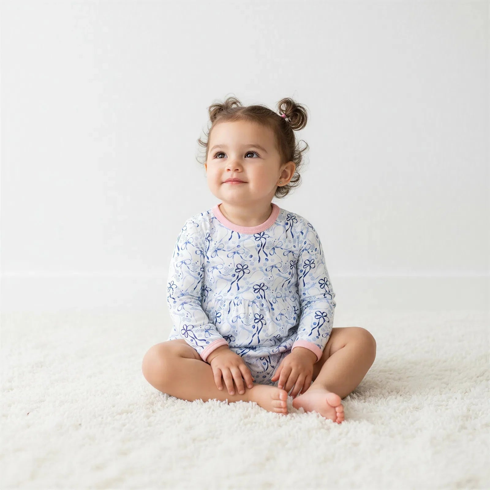 Long-sleeve bodysuit dress with blue bows, menorahs, Star of David and dreidel print on a light background