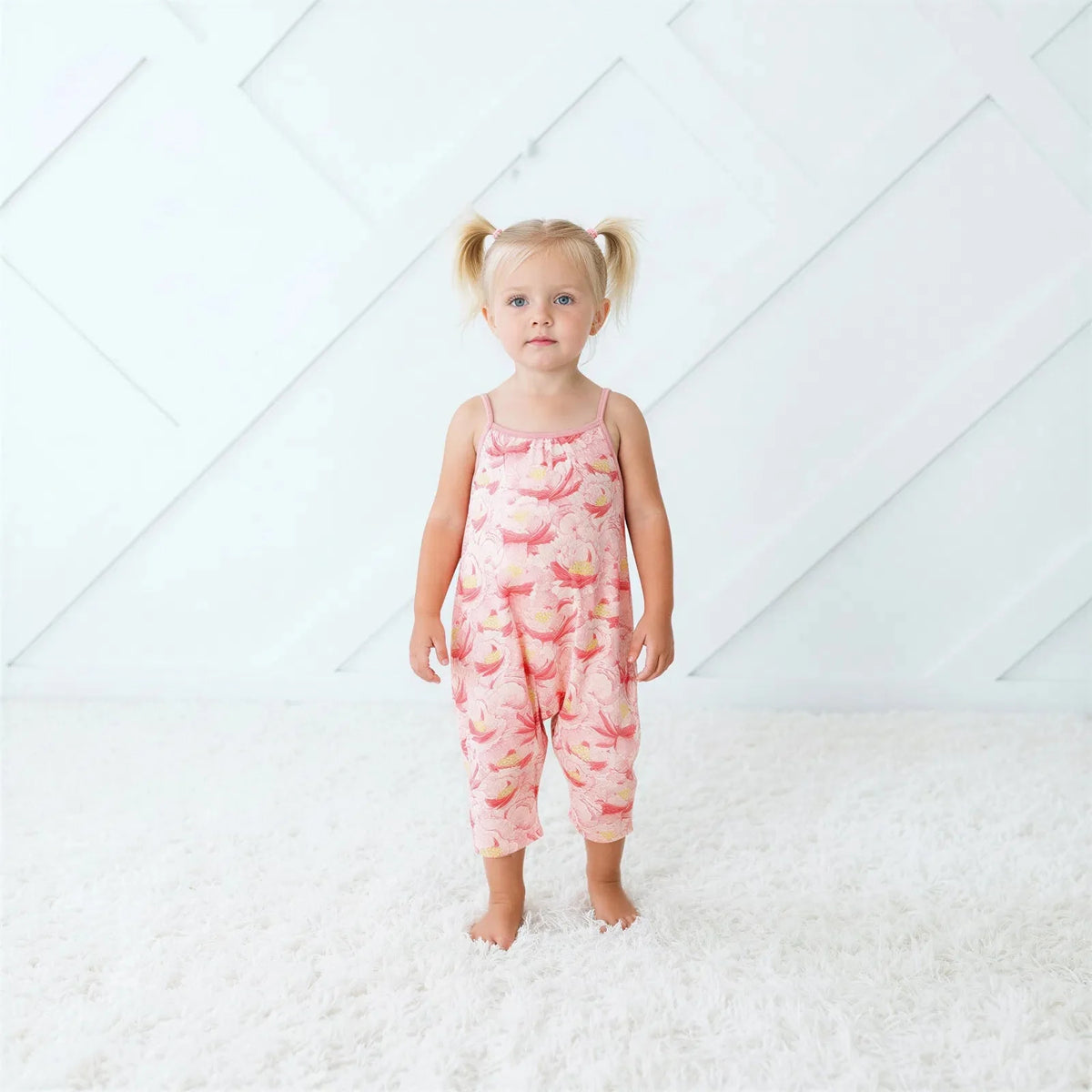 Blush pink floral jumpsuit with pockets on a toddler