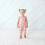 Blush pink floral jumpsuit with pockets on a toddler