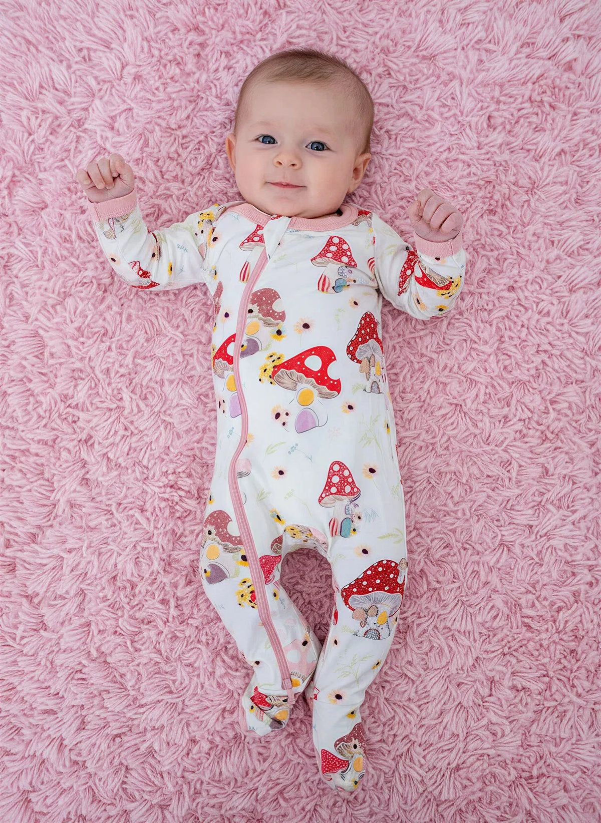 Baby footie pajamas in a Flora Shrooms mushroom print with full-length zipper and fold-over mittens